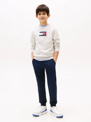 Boy wearing the Tommy Hilfiger flag logo track bottoms.