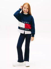 Girl in navy flared leggings by Tommy Hilfiger.