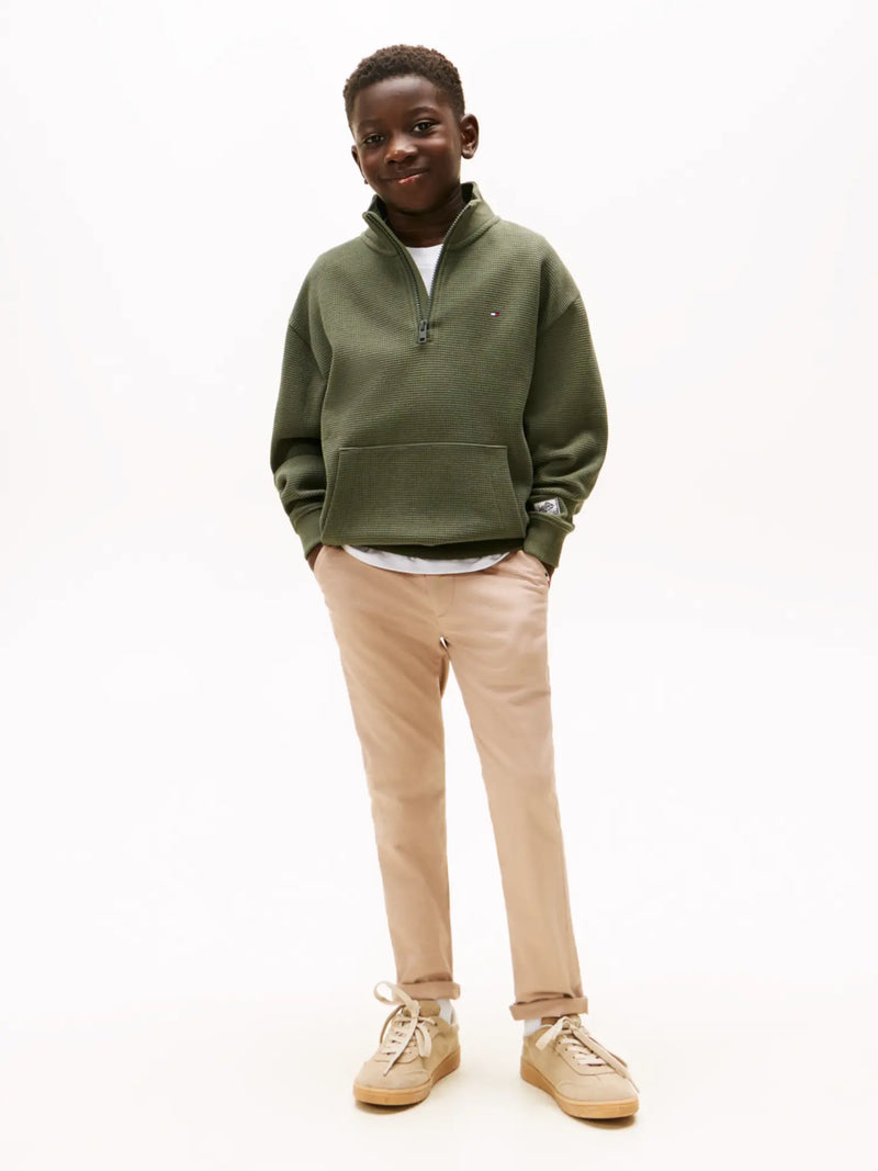 Boy modelling the Tommy Hilfiger half zip sweatshirt.