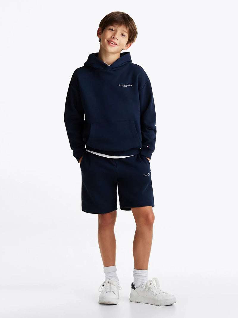 Boy modelling the Tommy Hilfiger logo track shorts.