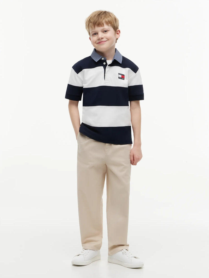 Boy in navy rugby shirt by Tommy Hilfiger.