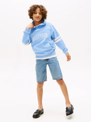 Boy in blue script logo hoodie by Tommy Hilfiger.
