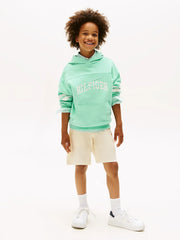 Boy wearing the Tommy Hilfiger script logo hoodie.