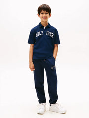 Boy wearing the Tommy Hilfiger script logo track bottoms.