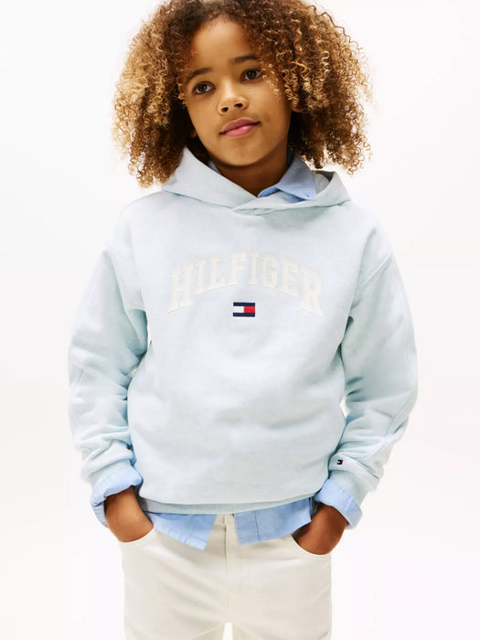 Boy wearing the Tommy Hilfiger varsity hoodie.