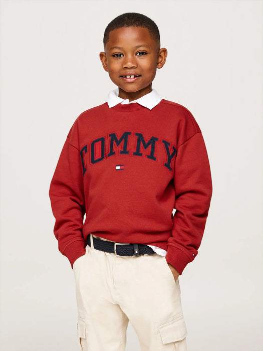 Boy wearing the Tommy Hilfiger varsity sweatshirt.