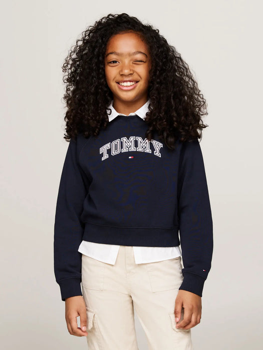 Smiling girl modelling the Tommy Hilfiger varsity sweatshirt.