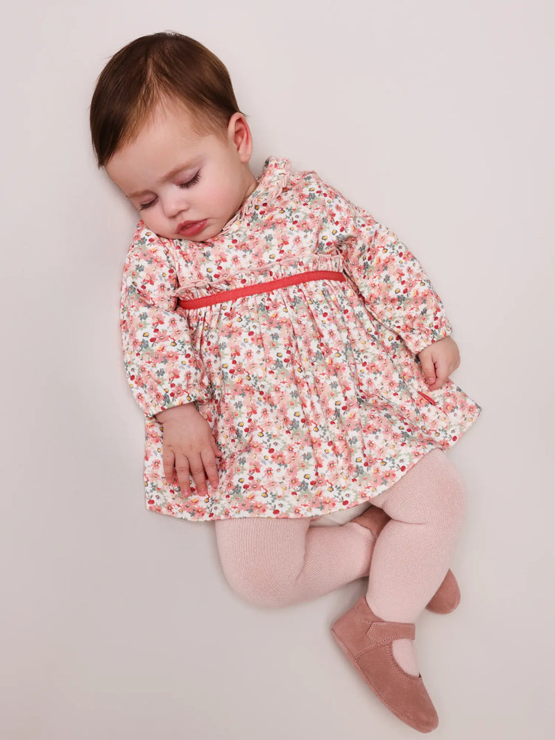 Sleeping baby girl in orange patio dress by Tutto Piccolo.