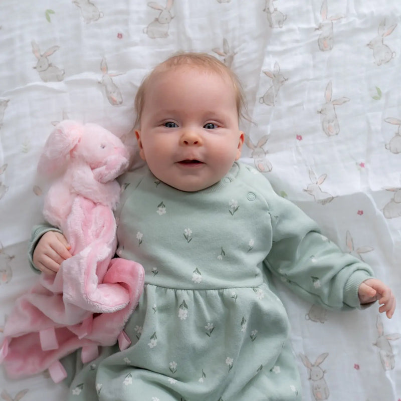 Baby holding the Ziggle bunny comforter.