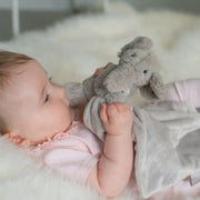 Baby girl clutching the Ziggle elephant comforter.