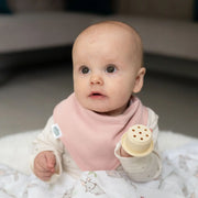 Baby wearing a blush pink Ziggle bandana bib.