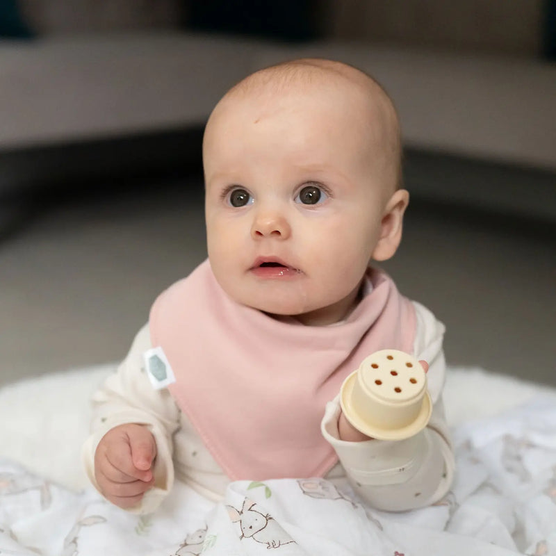 Baby wearing a blush pink Ziggle bandana bib.