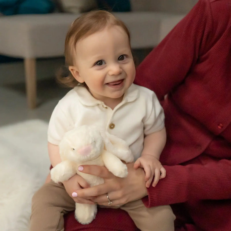 Smiling baby boy holding the Ziggle plush bunny.