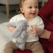 Smiling baby boy holding the Ziggle plush bunny.