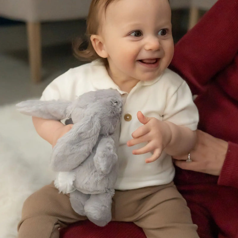 Smiling baby boy holding the Ziggle plush bunny.