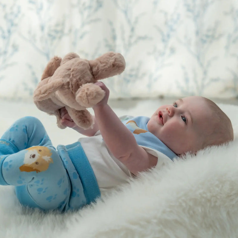 Baby boy clutching the ziggle plush puppy toy.
