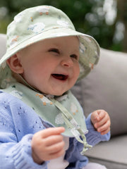 Smiling baby wearing the ziggle sheep sun hat.