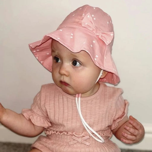 Baby girl wearing the Ziggle Pink Stars Sun Hat.