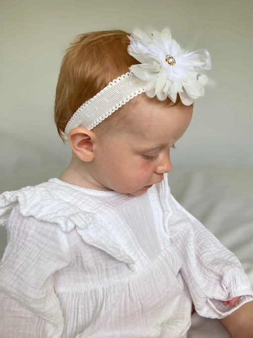 Girl wearing the Ziggle white flower headband.