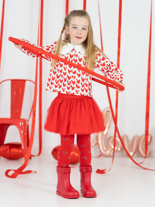 Girl modelling the Agatha Ruiz de la Prada heart print skirt set while using a red hula hoop. 