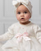Baby girl wearing the Ivory Caramelo Diamante Dress.