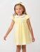 Girl wearing the Caramelo smocked dress.