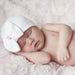 Sleeping baby wearing the Newborn Baby's Bow Hat - White