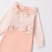 Pink iDo babygrow with floral print ruffles across the chest.