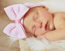 Sleeping baby wearing the Newborn Baby's Bow Hat - Pink