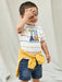 Smiling baby boy modelling the Mayoral denim bermuda shorts.