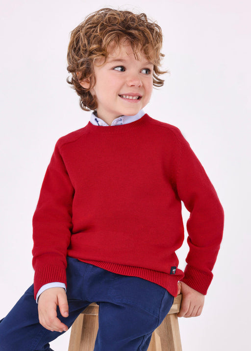 Smiling boy modelling the Mayoral knitted jumper.