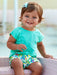 Smiling baby girl modelling the Mayoral palm tree shorts set.