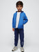 Smiling boy modelling the Mayoral three piece tracksuit.